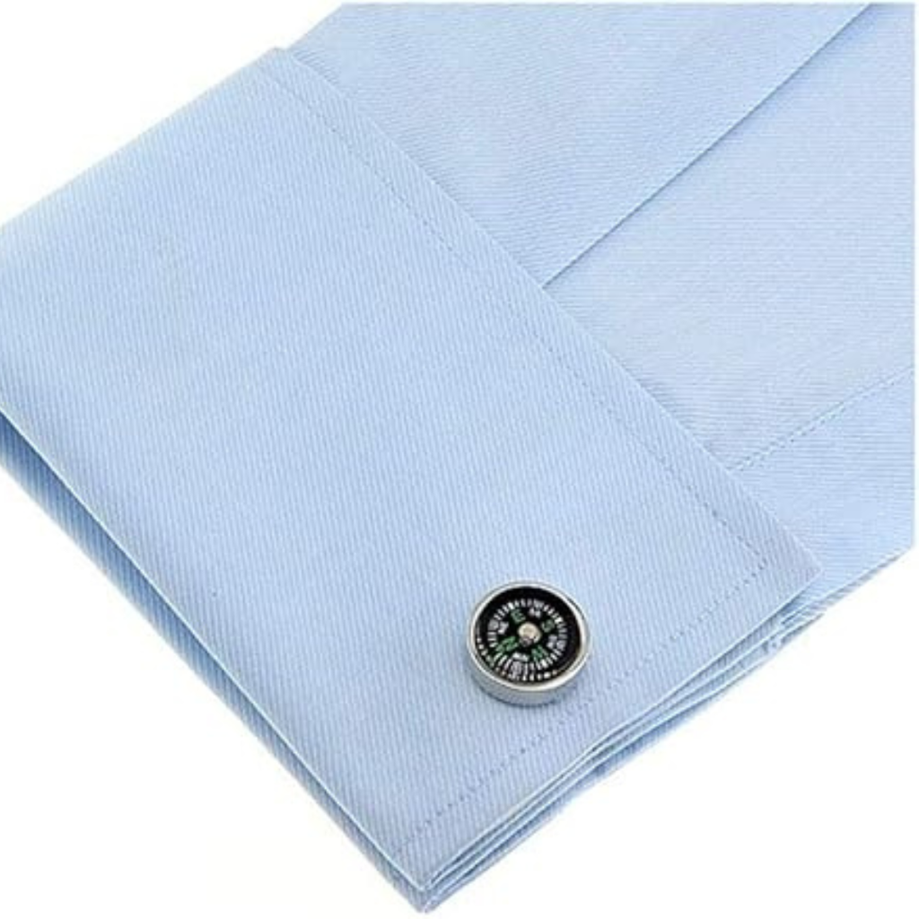 Compas Cufflink on a light blue textured fabric background