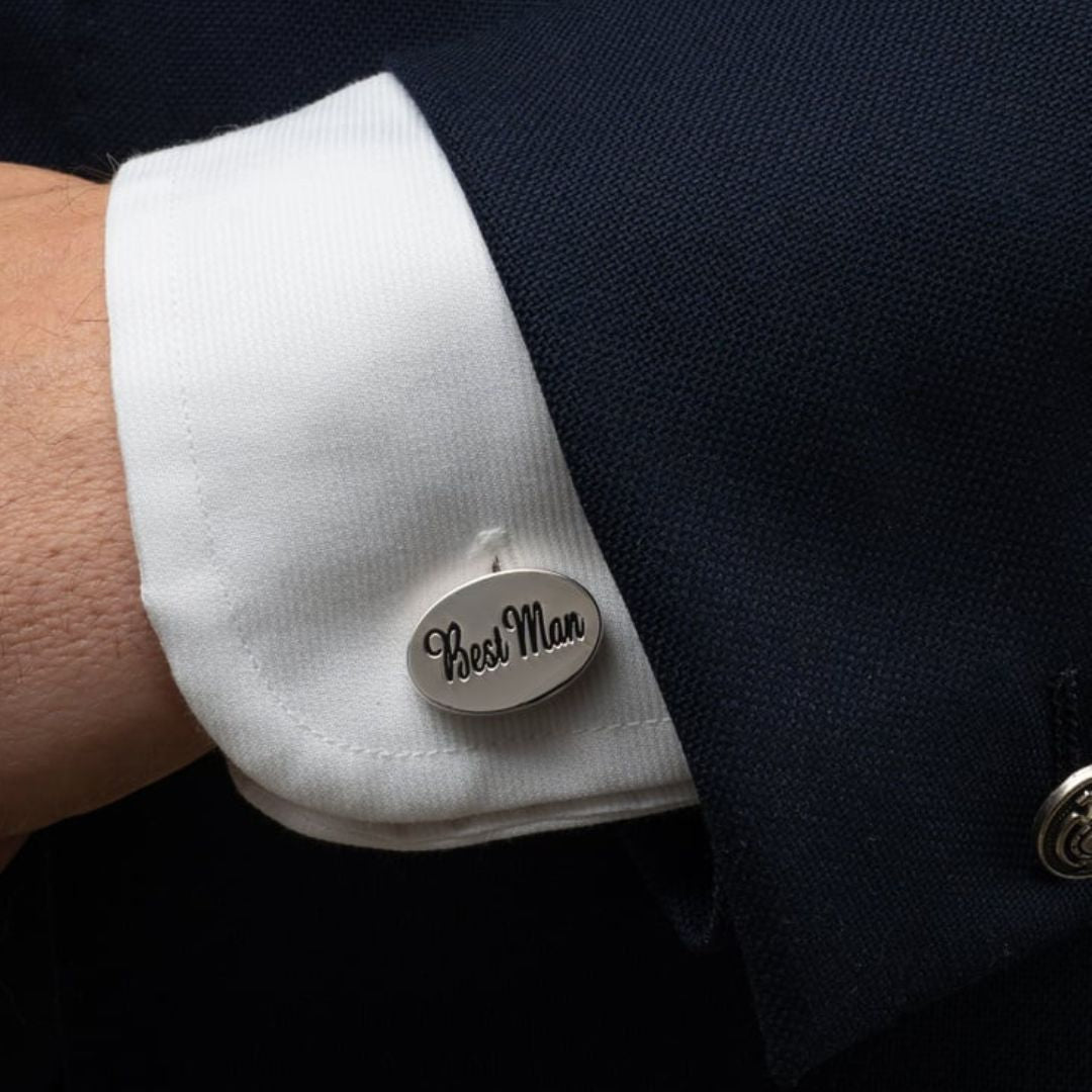 Cufflink with 'Best Man' text on a white cuff against a dark suit background