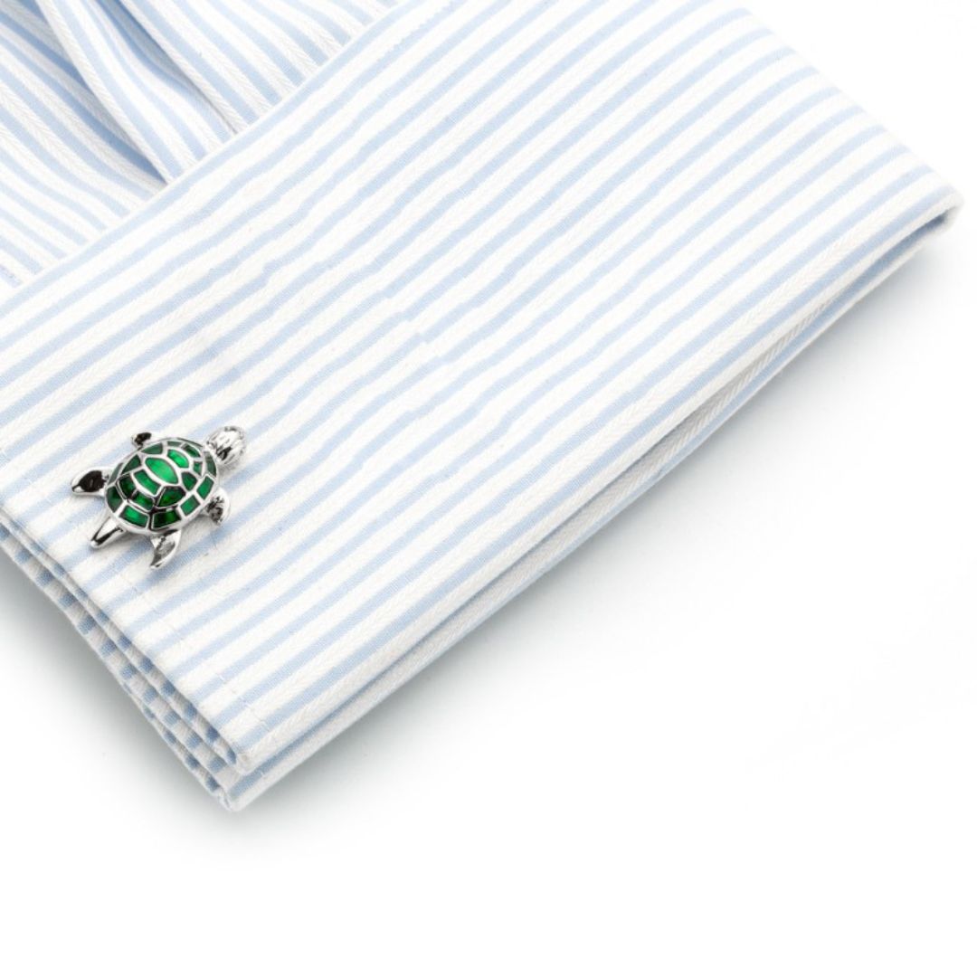 Cufflinks shaped like a turtle on a striped shirt