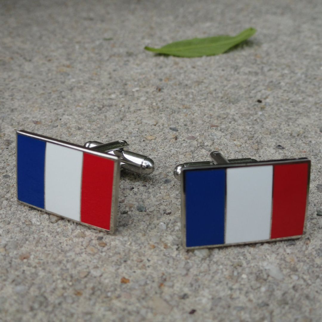 Cufflinks with French flag design on a concrete surface