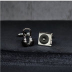 DJ Silver cufflinks shaped like a record player and headphones on a dark fabric background