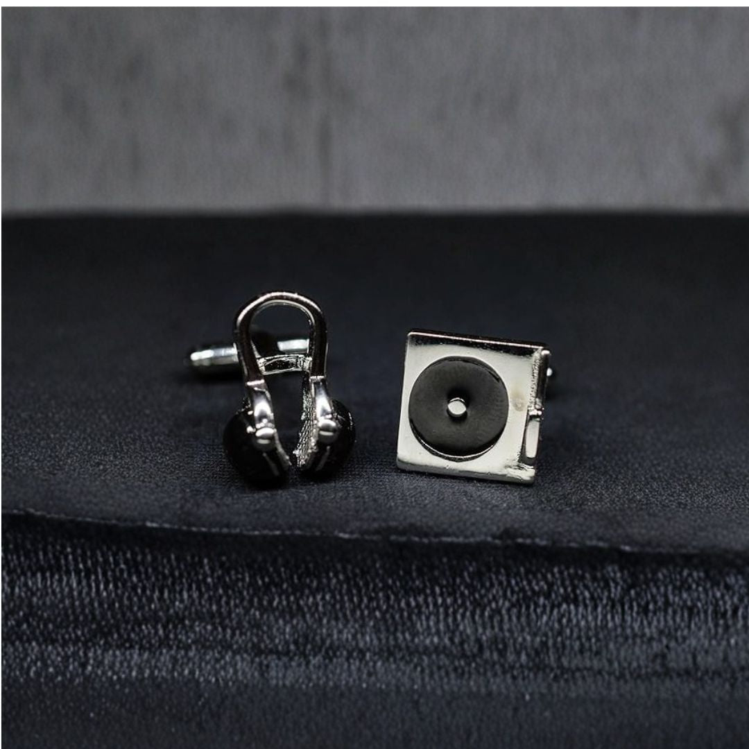 DJ Silver cufflinks shaped like a record player and headphones on a dark fabric background