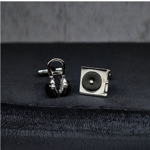 DJ Silver cufflinks shaped like a record player and headphones on a dark fabric background