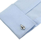 Silver anchor cufflink on a light blue pocket square