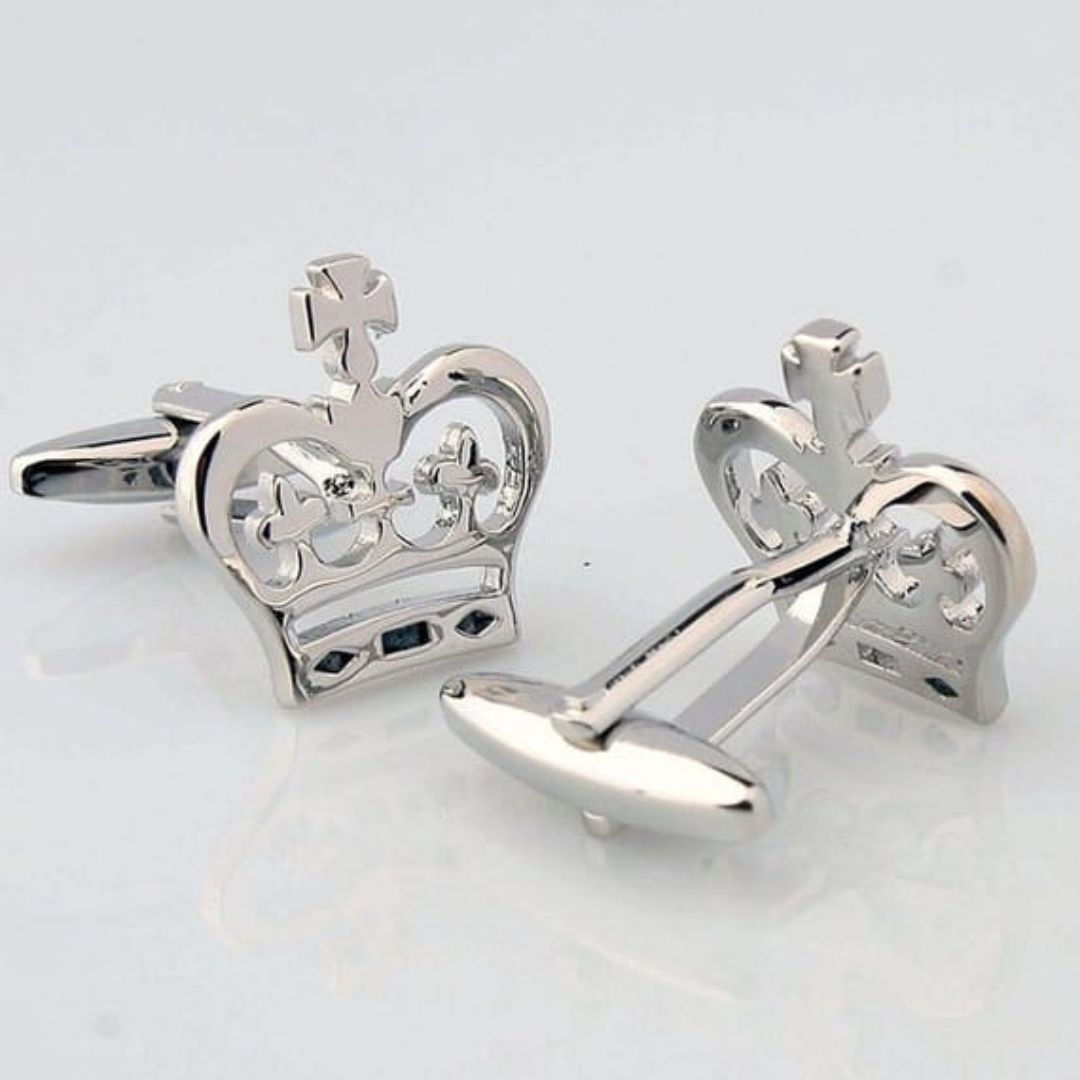 Silver crown-shaped cufflinks on a light gray background